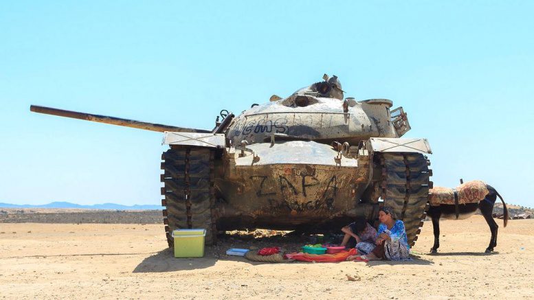 Mittagspause in der Wüste unter einem Panzer