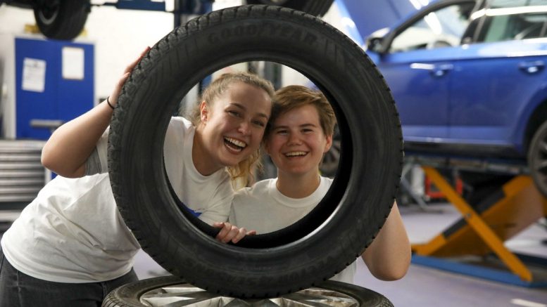 Ausbildungsjahr 2019 zwei Technik-Azubis schauen durch einen Reifen