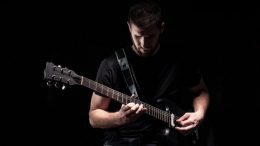 Musiker mit Gitarrre spielt im Dunkeln