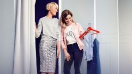 Zwei Frauen an einer Umkleidekabine probieren Mode an