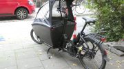 schwarze Lastenbike mit Windschutz aus PVC-Klarsicht