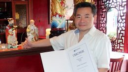 Restaurantinhaber Chi Sing Wong vom Restaurant Shanghai in Fuhlsbüttel mit Ehrenurkunde
