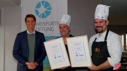 Dr. Niels Kohlschütter, Vorstand der „Schweisfurth Stiftung“, zeichnet Jens Witt und Sebastian Junge mit der Tierschutz- Kochmütze