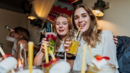 Zwei junge Frauen trinken Cocktails an der Bar