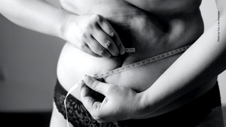 Ein Frau mit Bauch und Maßband - Übergewicht