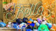 Schriftzug Bella an einer Hauswand, davor viel Müll und Abfälle