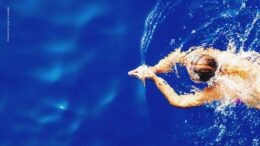 Ein Frau schwimmt im dunkelblauen Wasser