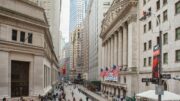 Die Wall Street in New York mit der New York Stock Exchange Börse und US-Flaggen